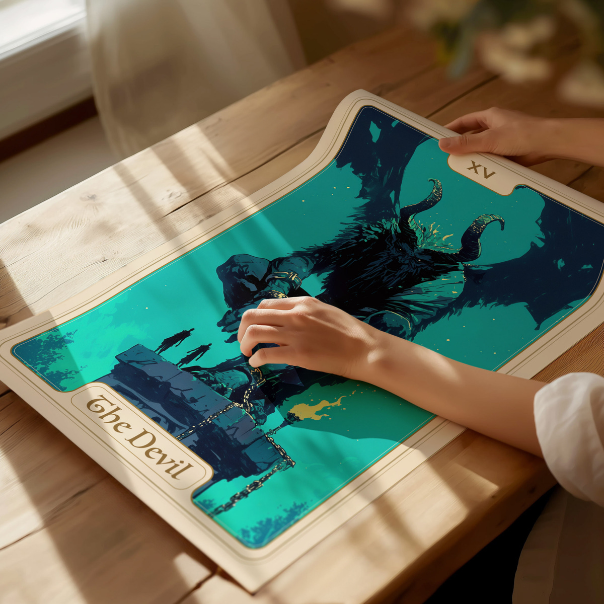 A person gently touches a colorful illustration of a horned figure, labeled The Devil, on a wooden table. The artwork features dark tones and vibrant accents, set against a mystical background with a chain and flames.