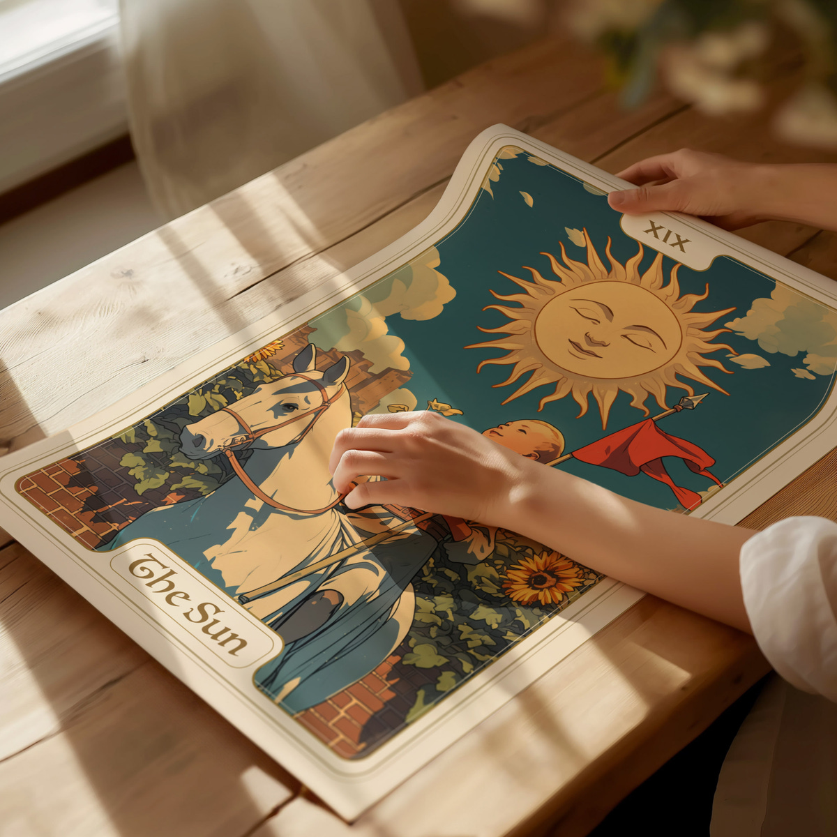 A person is gently touching a colorful illustration featuring the sun, with a smiling face and rays, surrounded by a blue sky and sunflowers. The design includes a figure on a horse and another character, labeled The Sun at the bottom.
