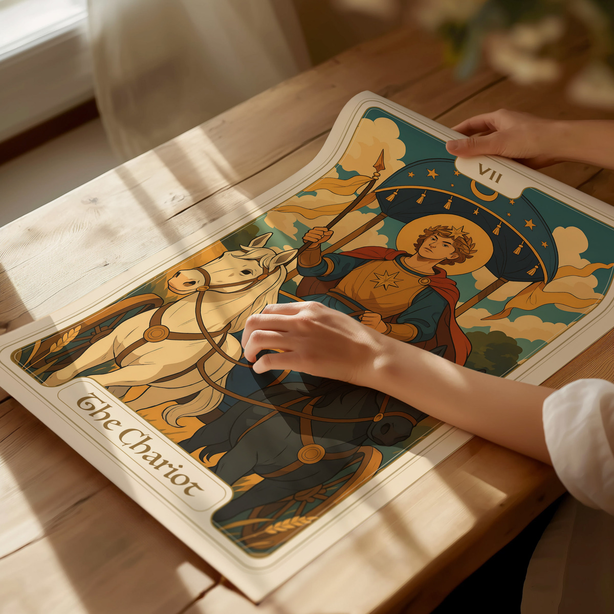 A person’s hand gently touches a colorful tarot card depicting The Chariot, featuring a regal figure with a crown and a flowing robe, holding a staff, accompanied by two horses.