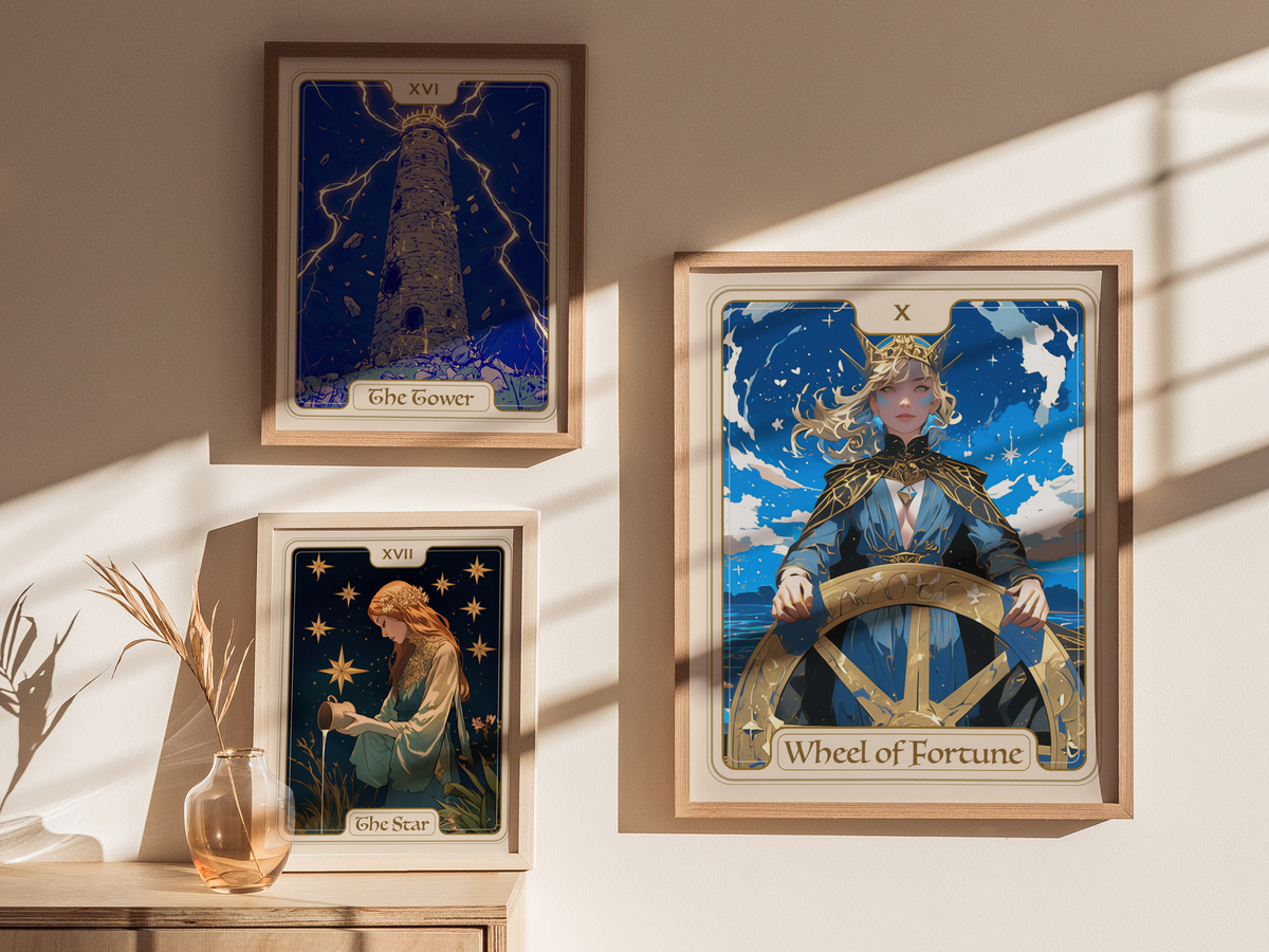 Three framed tarot cards are displayed on a light-colored wall. The central card features the Wheel of Fortune, depicting a figure at a ships wheel against a starry sky, while the other two cards, The Tower and The Star, are.