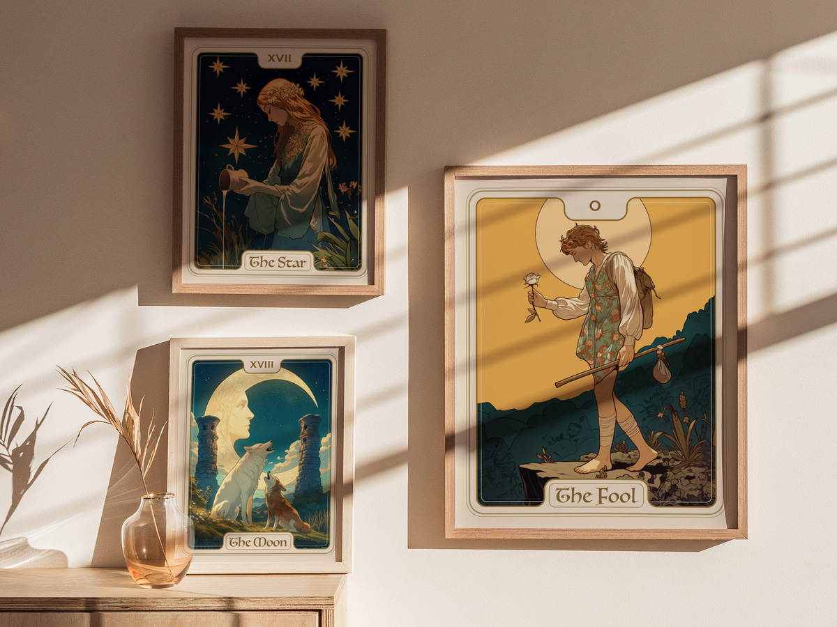 A cozy room with natural light streaming in showcases three framed tarot card artworks on a light-colored wall. The central piece, titled The Fool, depicts a youthful figure holding a small flower, symbolizing new beginnings and adventure.