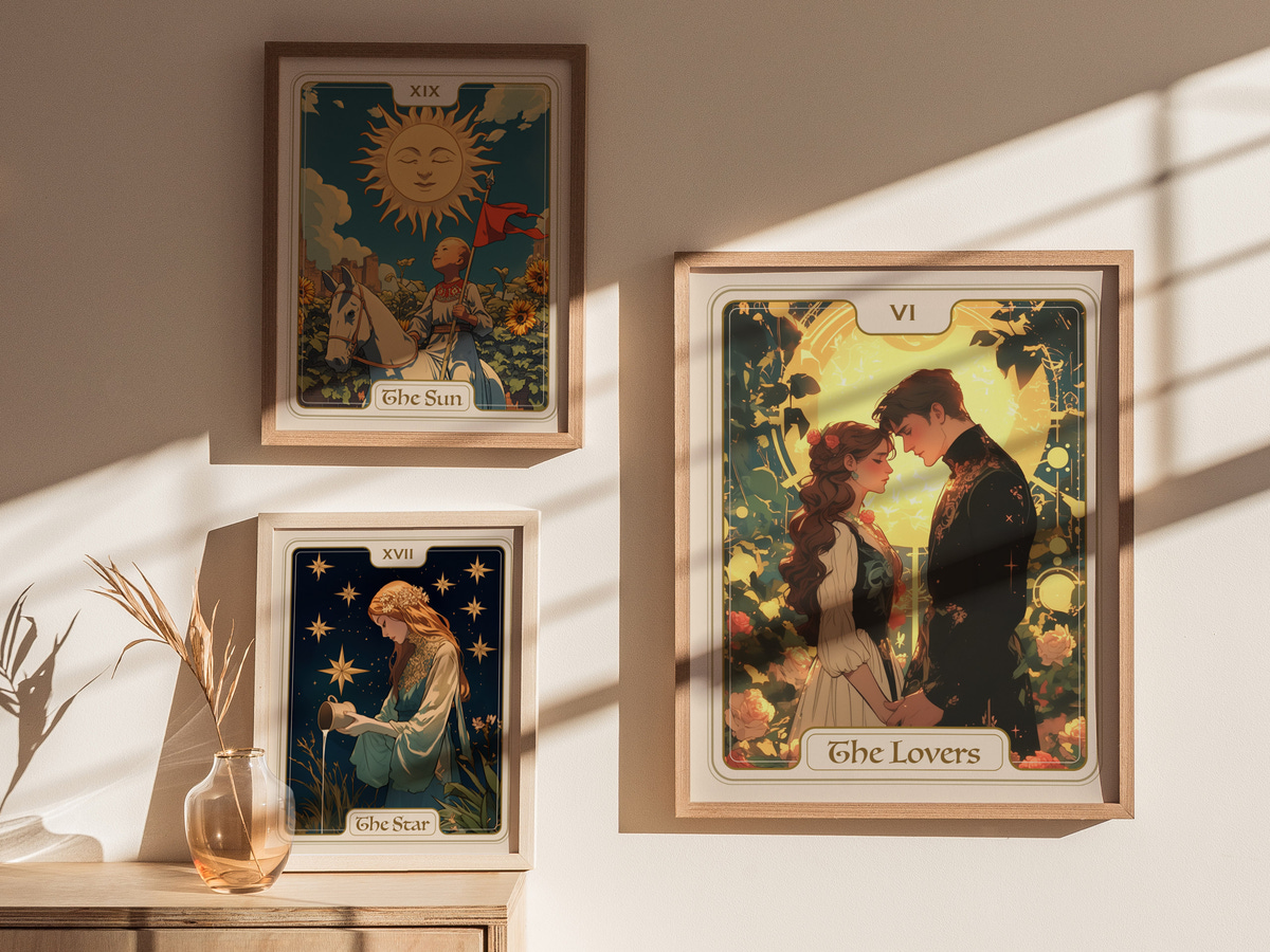 A cozy interior features three framed tarot card illustrations on a light-colored wall. The central card, titled The Lovers, depicts a couple embracing, surrounded by floral motifs, while The Sun and The Star cards are displayed above.