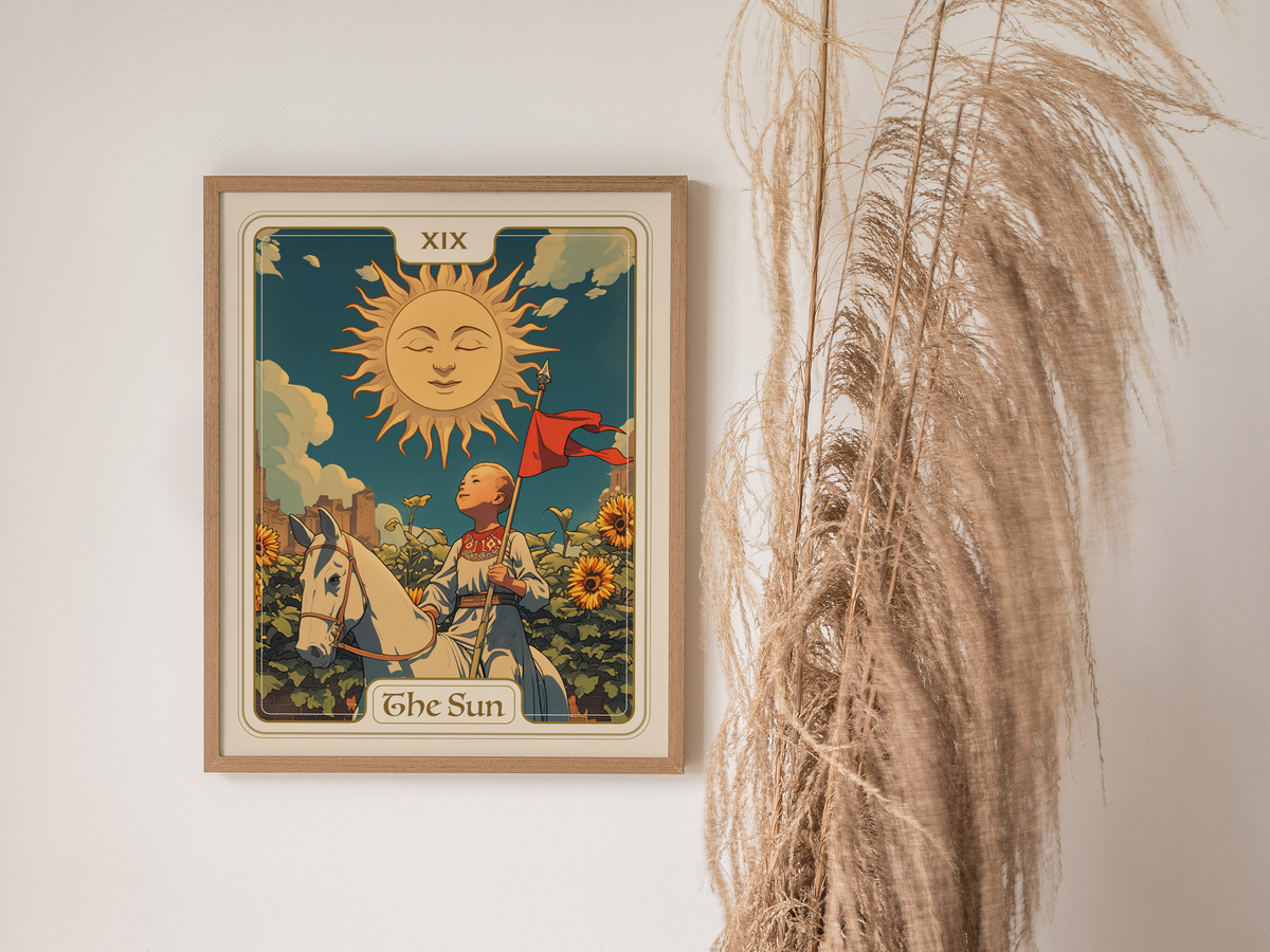 A vibrant illustration features a sun with a smiling face positioned above a child holding a red flag, surrounded by sunflowers and greenery. The artwork is framed and displayed against a light wall, accompanied by tall, dry pampas grass.