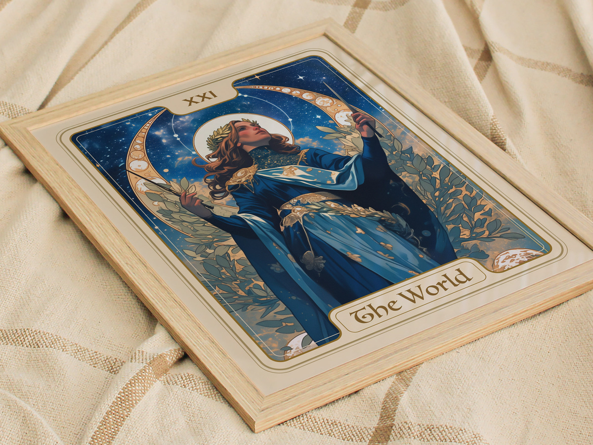 A beautifully illustrated tarot card featuring a figure adorned in a flowing blue gown, surrounded by stars and floral elements. The card, labeled The World, is framed and resting on a textured, neutral-colored fabric.